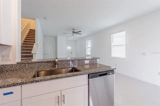 a kitchen with a granite countertop sink and cabinets