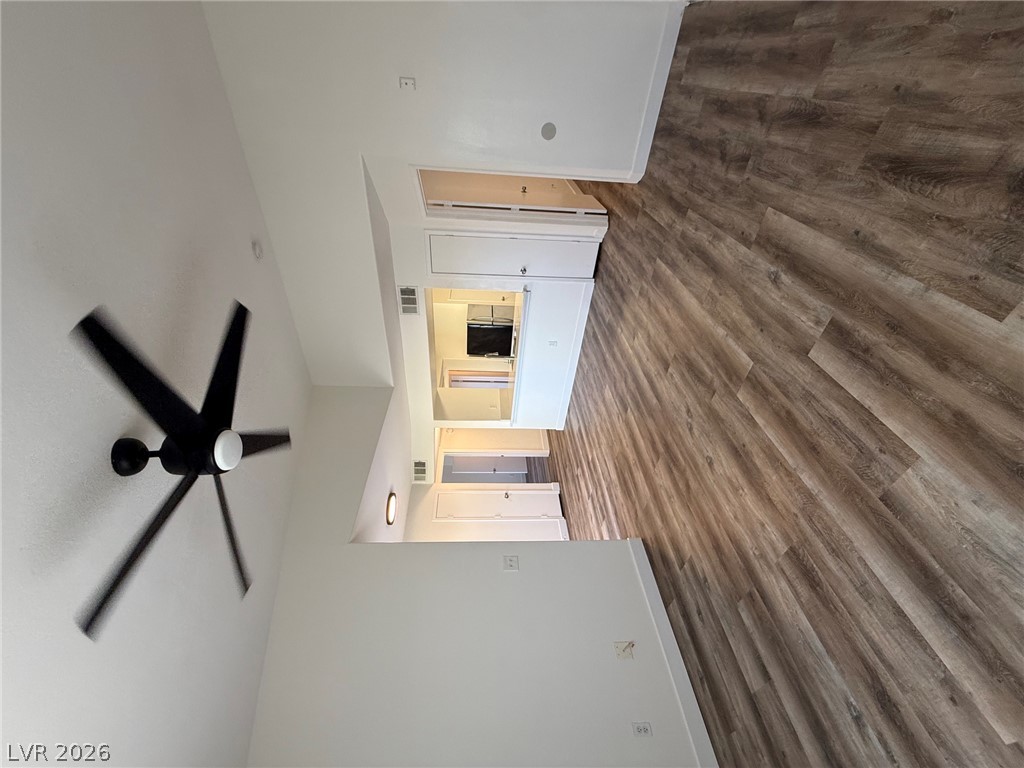 7255 West Sunset Road, Unit 2149 Las Vegas, NV 89113 - Photo 5 of 28 Wood plank flooring and a modern ceiling fan elevate this open concept living space.