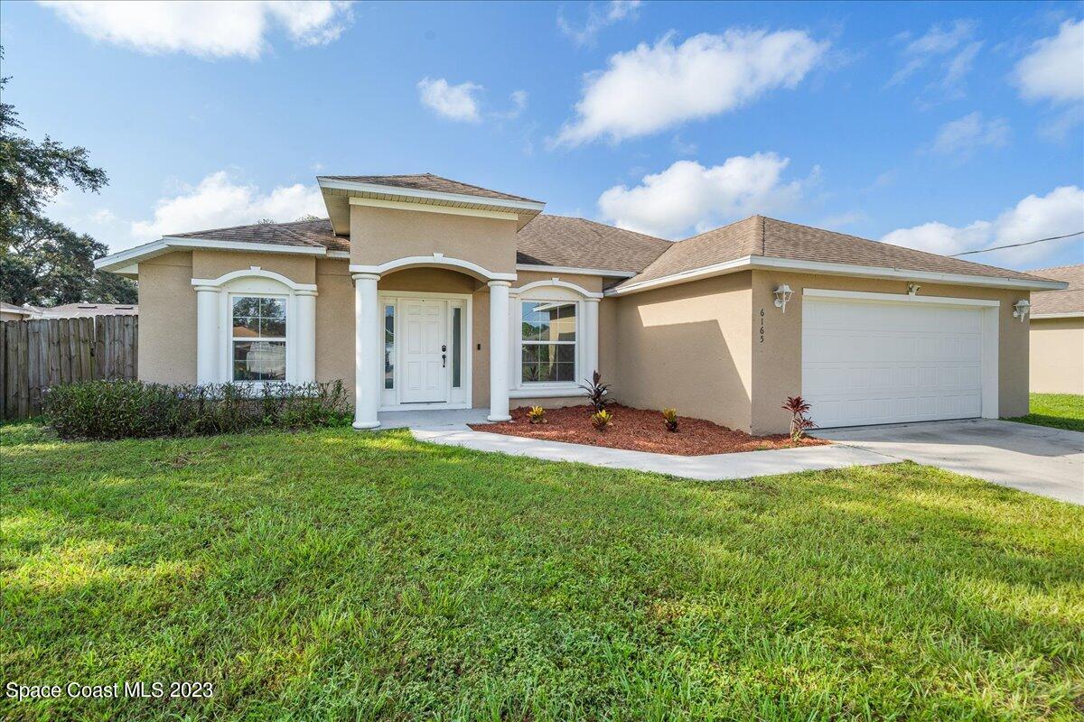 6165 Adina Road Cocoa, FL 32927 - Photo 4 of 31 a front view of a house with a garden and yard