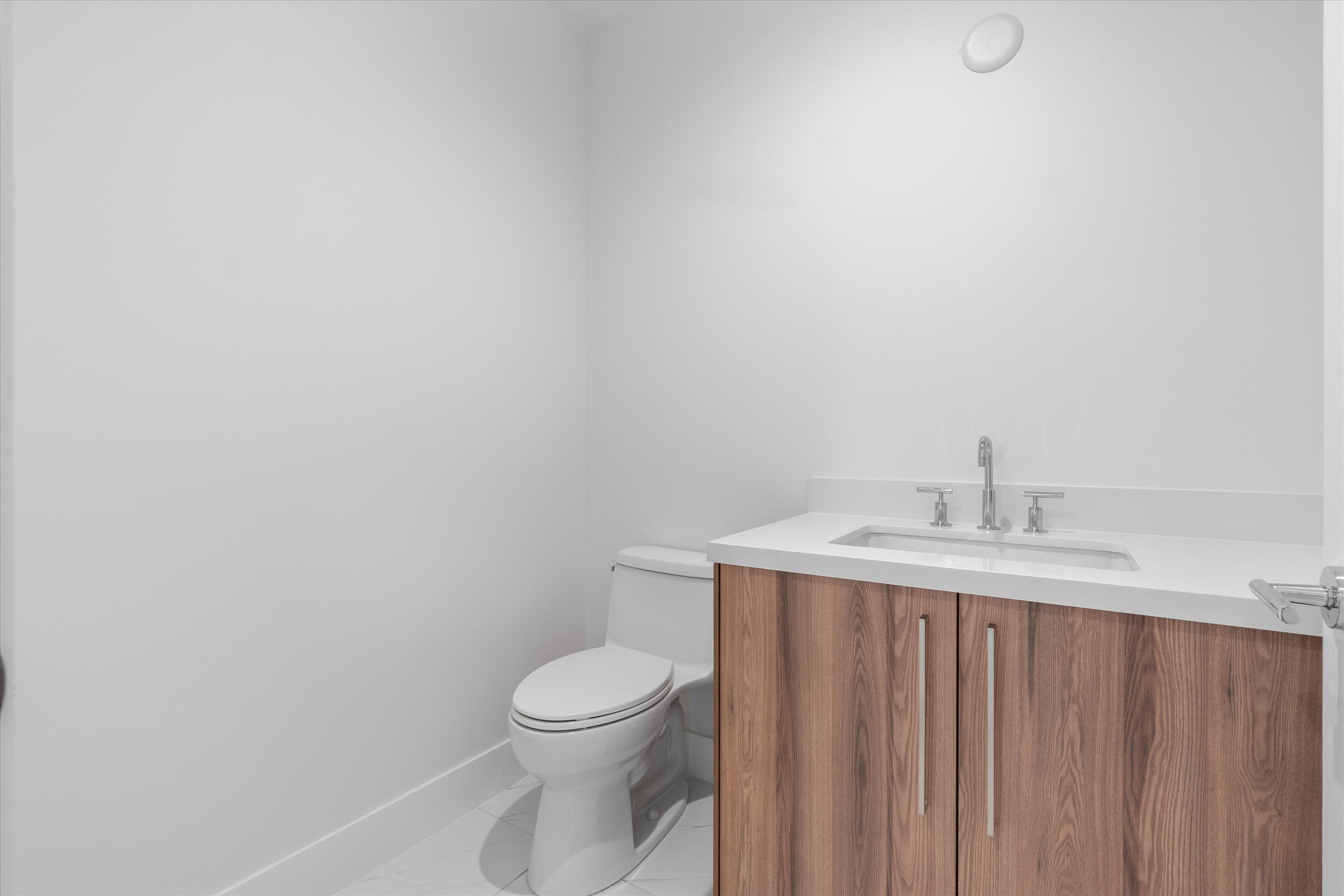 495 East Royal Palm Road, Unit 402 Boca Raton, FL 33432 - Photo 17 of 72 a bathroom with a toilet a sink and mirror