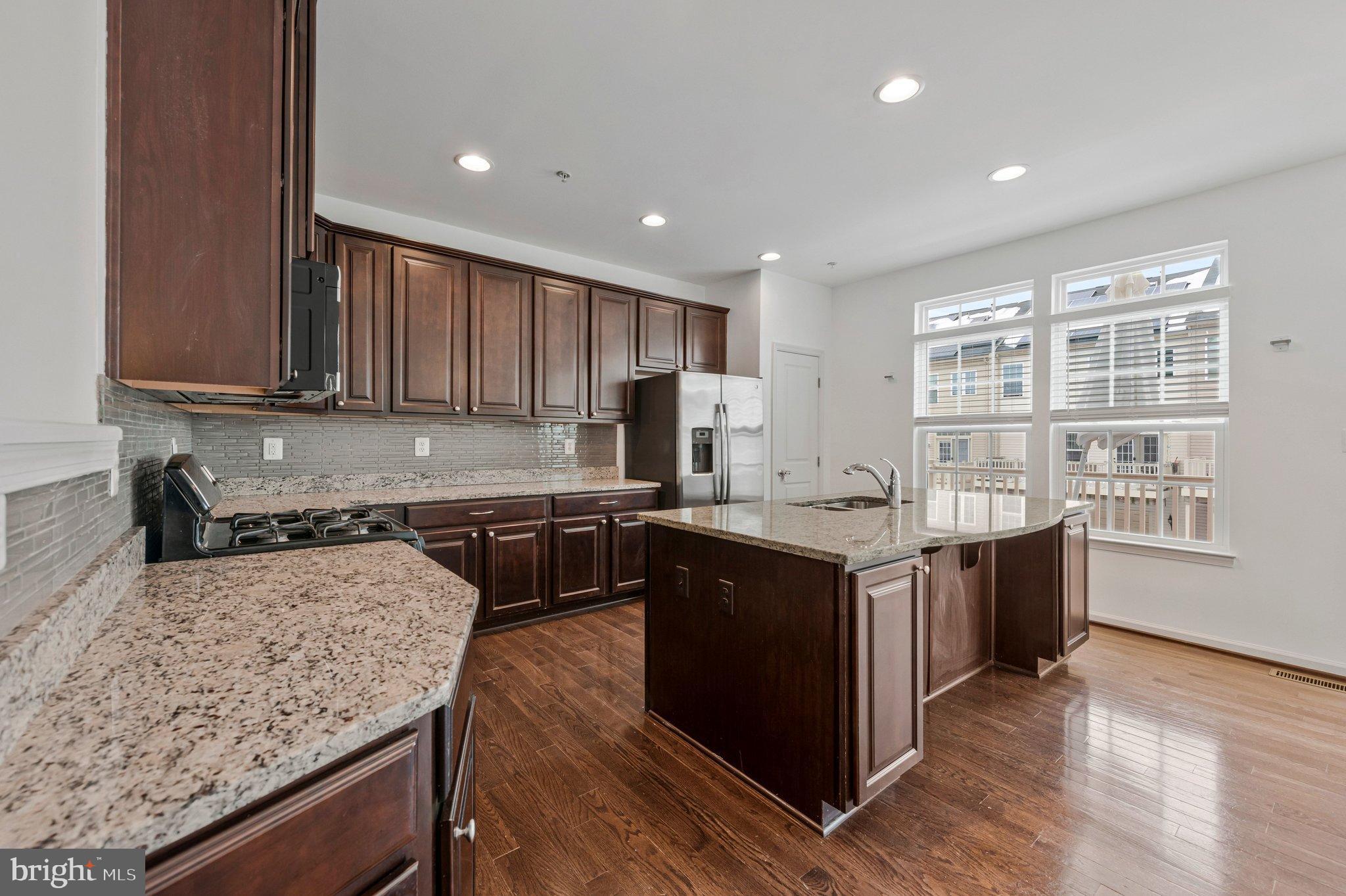606 Chance Place Capitol Heights, MD 20743 - Photo 15 of 39 a kitchen with stainless steel appliances granite countertop a stove a sink and a refrigerator