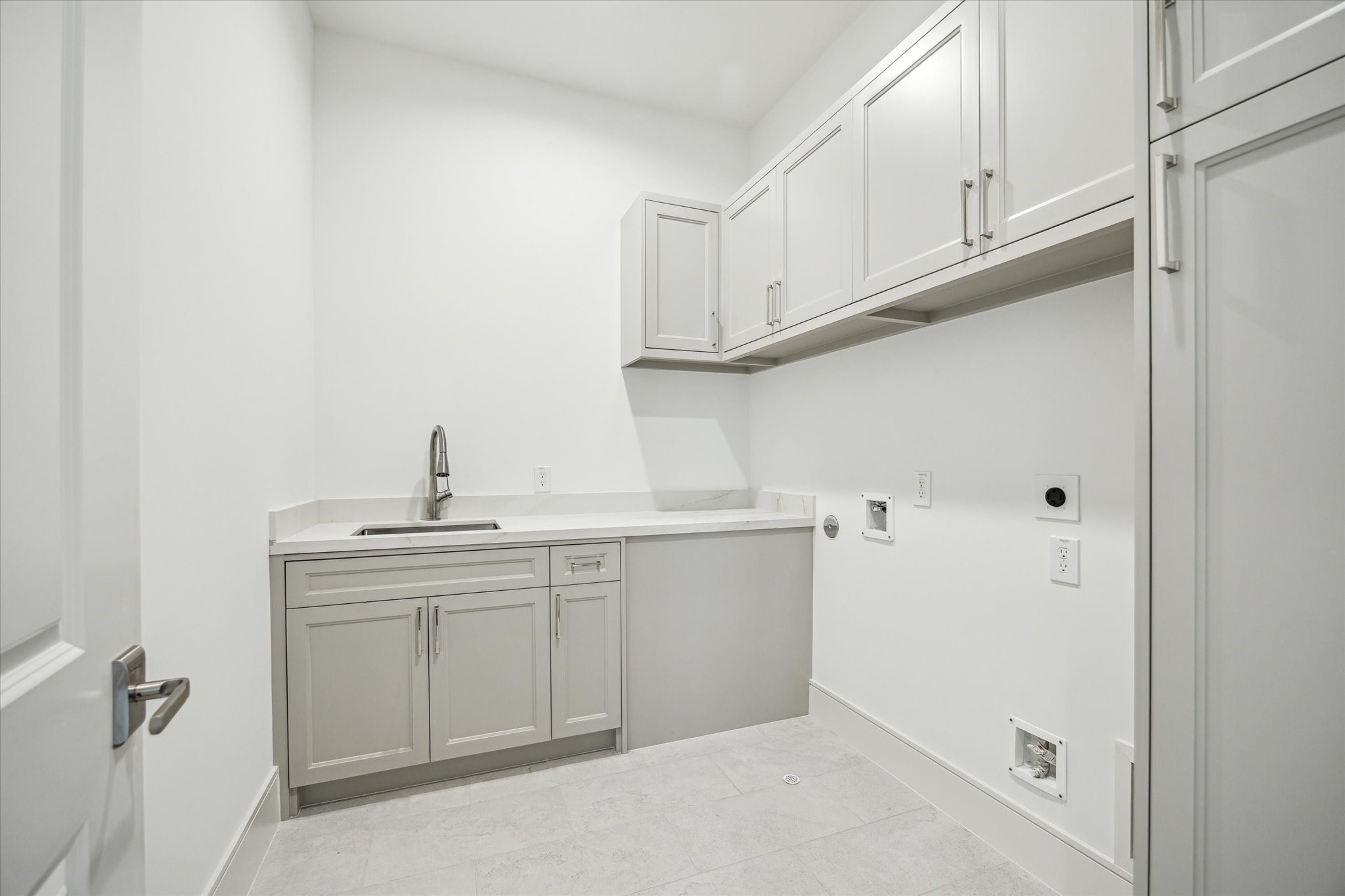 209 Sutton Row Place Houston, TX 77024 - Photo 14 of 23 Second-floor utility room features sink and cabinet storage.
