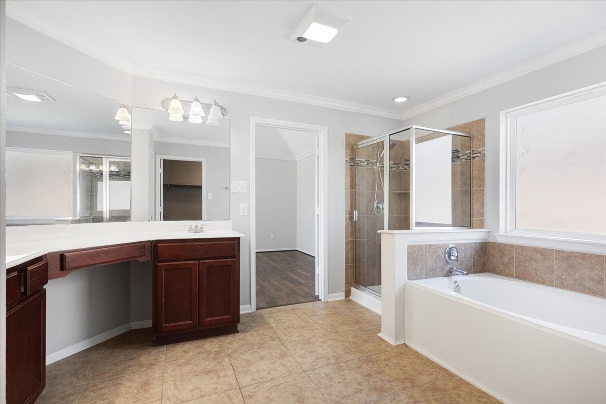 5446 Seabird Street Baytown, TX 77521 - Photo 12 of 23 The primary bath features a separate shower and soaking tub, creating a spa-like space perfect for relaxation.