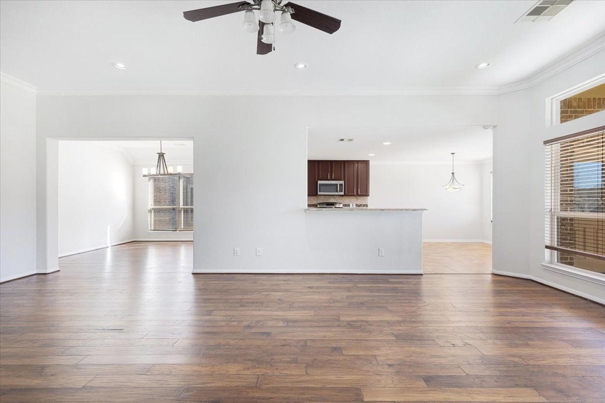 5446 Seabird Street Baytown, TX 77521 - Photo 7 of 23 This view highlights the dining room seamlessly connected to the kitchen and open to the living room, creating a bright and inviting open-concept layout ideal for entertaining.