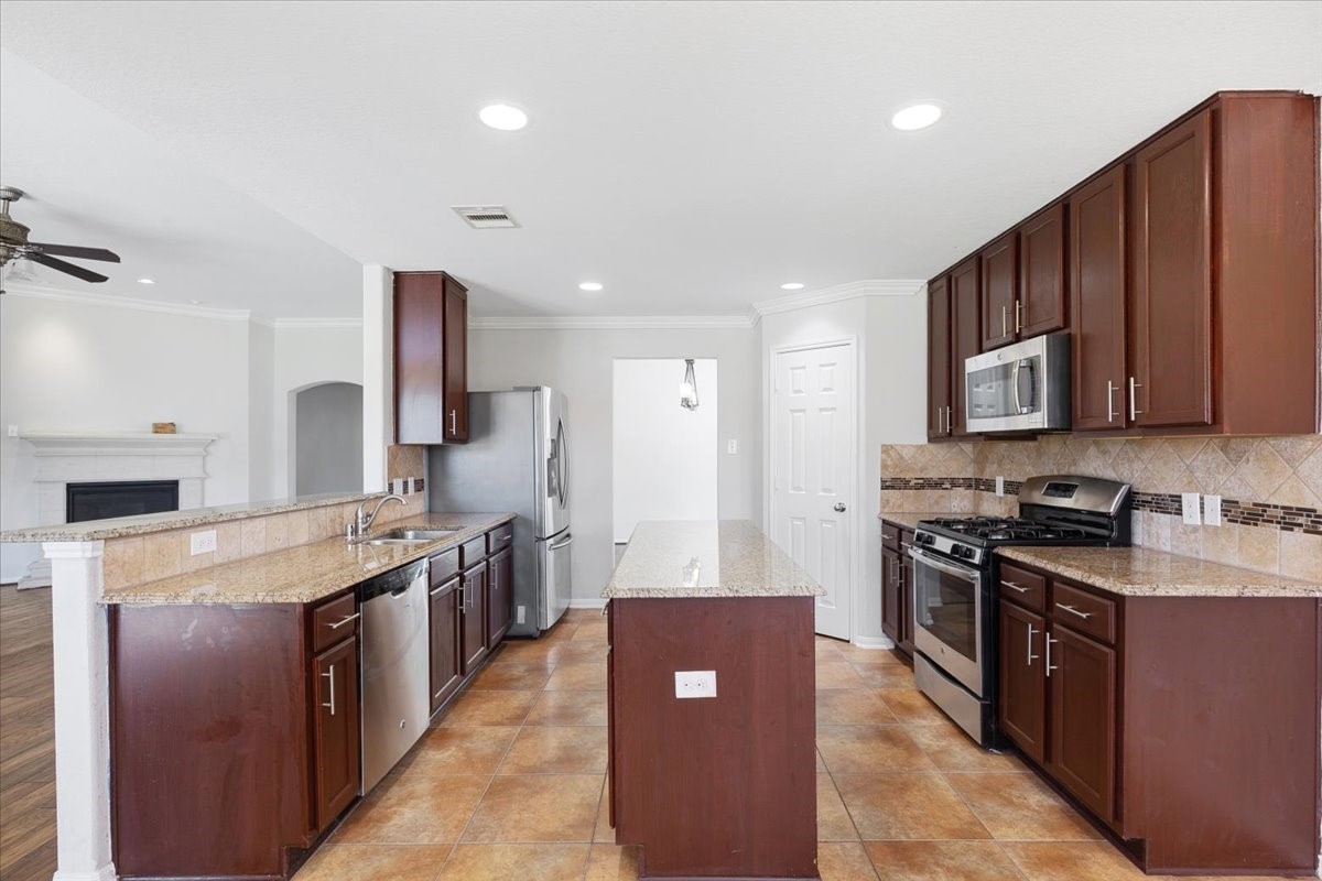 5446 Seabird Street Baytown, TX 77521 - Photo 8 of 23 The kitchen features a central island that provides additional workspace and serves as a perfect gathering spot for cooking and entertaining.