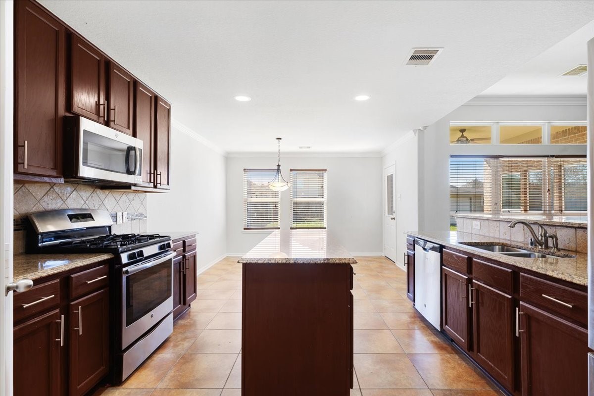 5446 Seabird Street Baytown, TX 77521 - Photo 9 of 23 The kitchen includes a cozy breakfast nook, offering a bright and comfortable space for casual meals and morning coffee.