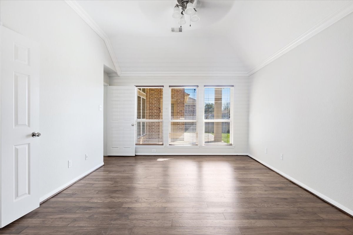 5446 Seabird Street Baytown, TX 77521 - Photo 10 of 23 The primary bedroom is a spacious and relaxing retreat, enhanced by large windows that fill the room with natural light.