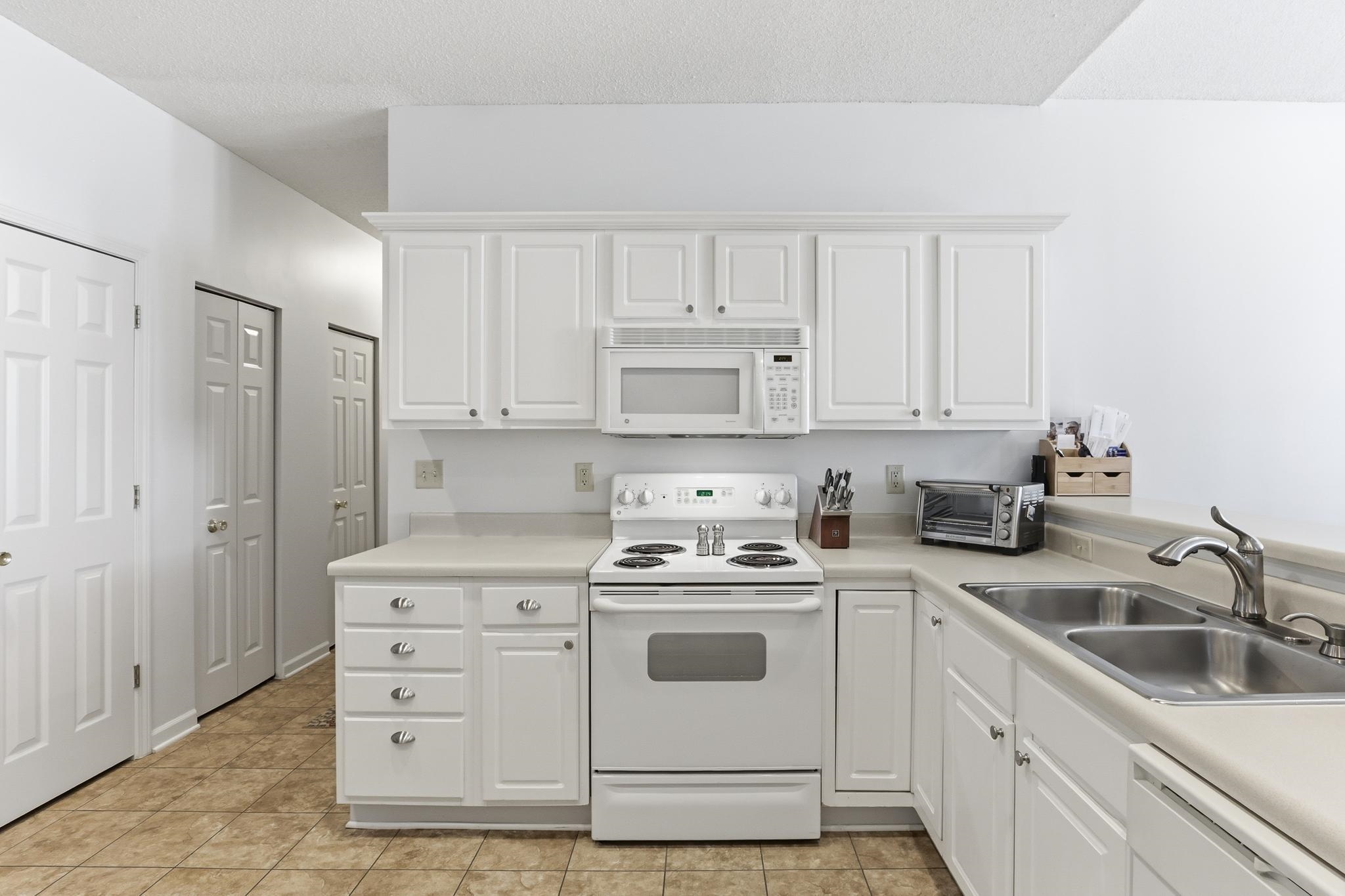 1075 Oak Timber Circle, Unit 69 Collierville, TN 38017 - Photo 21 of 35 a kitchen with white cabinets and white appliances