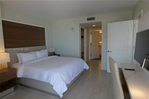 a bedroom with a bed and a television