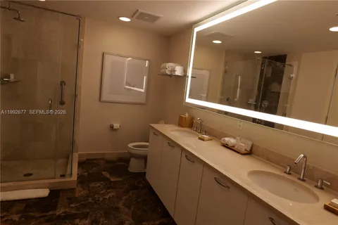a bathroom with a double vanity sink toilet and shower