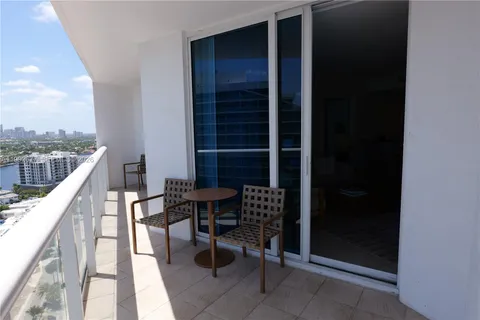 a balcony with table and chairs