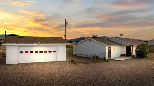 a white house with a small yard and a car parked