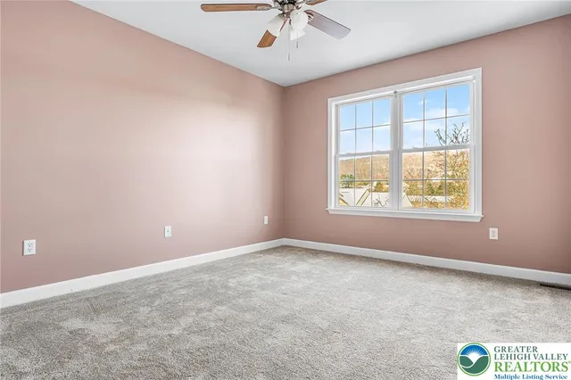 an empty room with a window and a fan