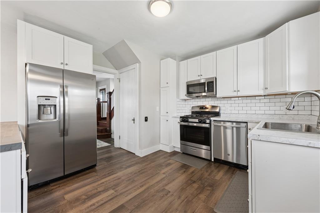 53 Calhoun Avenue Pittsburgh, PA 15210 - Photo 9 of 30 a kitchen with stainless steel appliances and wooden floor