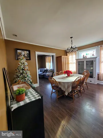 a living room with furniture pool table and paintings on the wall