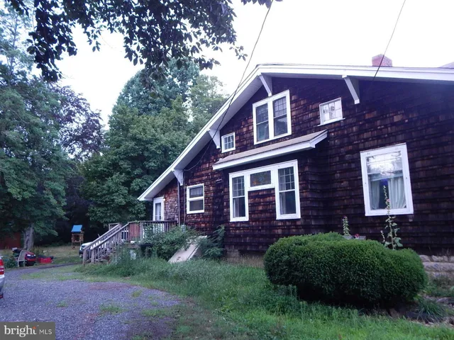 a brick house with a small yard and large trees