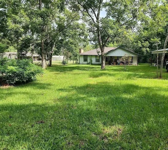 a front view of a house with a yard and trees