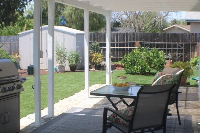 a view of a patio with a table chairs and a garden