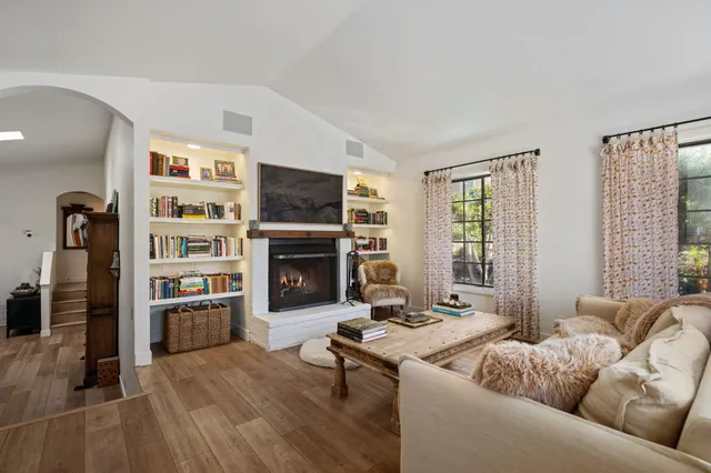 a bedroom with a bed and a couch with wooden floor