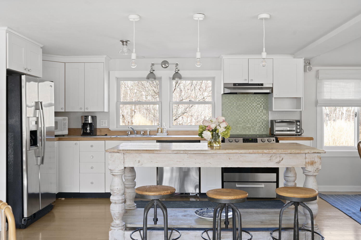 a kitchen with stainless steel appliances a dining table chairs microwave and cabinets