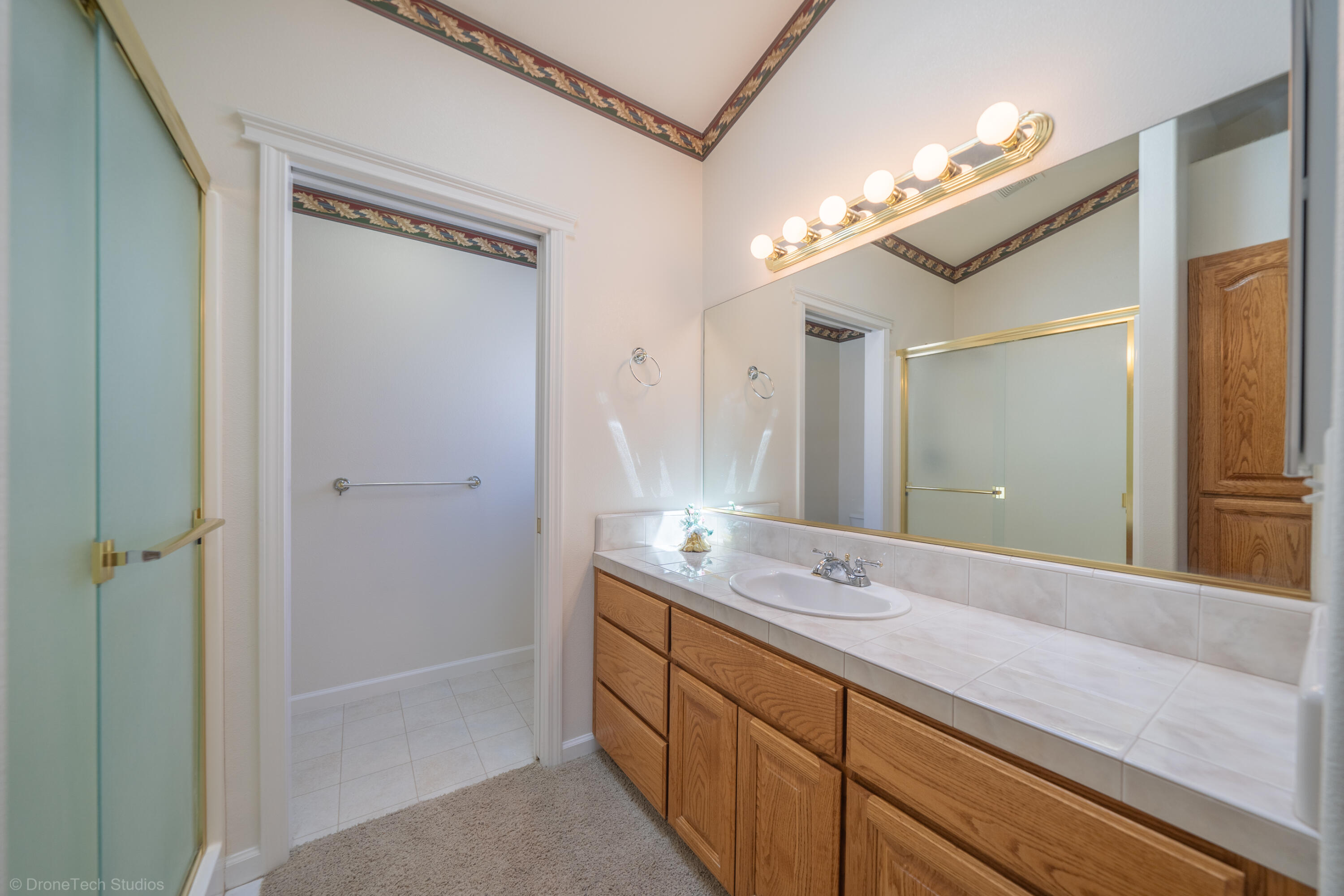 662 Volcano View Trail Redding, CA 96003 - Photo 13 of 26 a spacious bathroom with a double vanity sink a large mirror and a shower