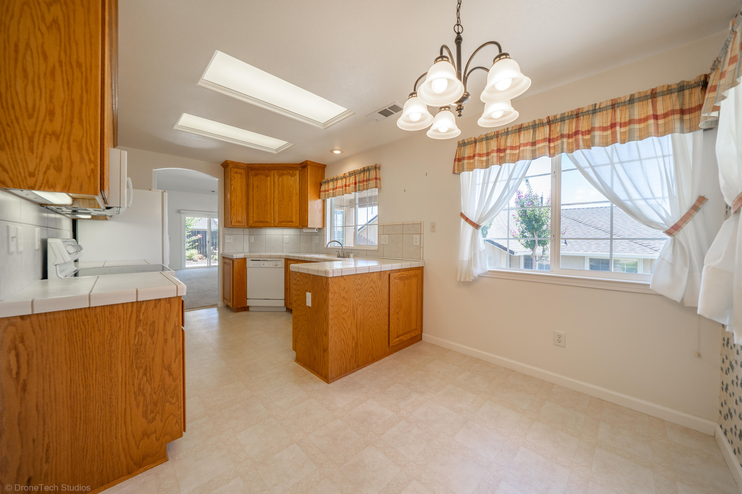 662 Volcano View Trail Redding, CA 96003 - Photo 8 of 26 a kitchen with a sink a counter top space stainless steel appliances a large window and cabinets