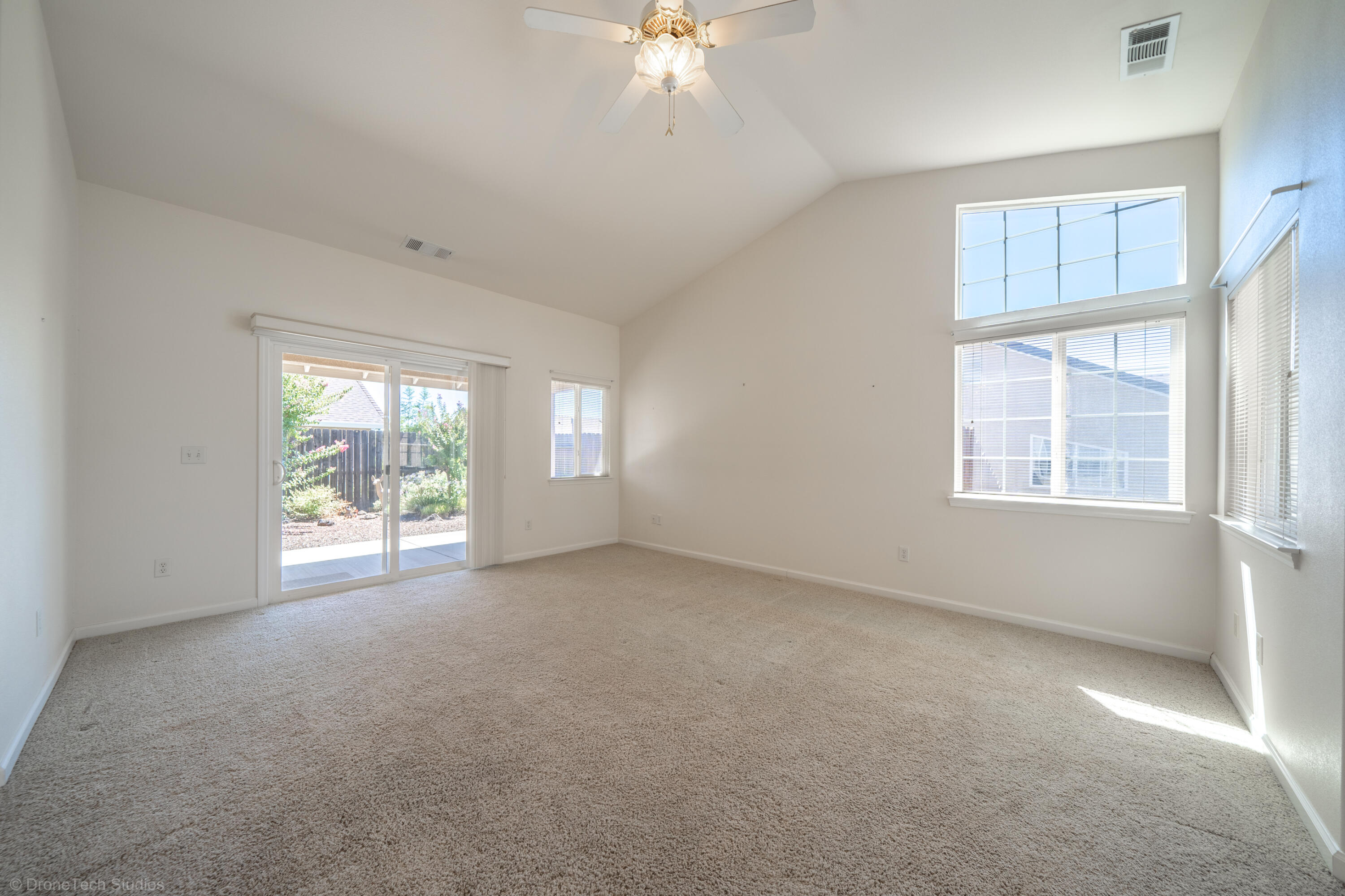 662 Volcano View Trail Redding, CA 96003 - Photo 10 of 26 an empty room with chandelier fan and windows