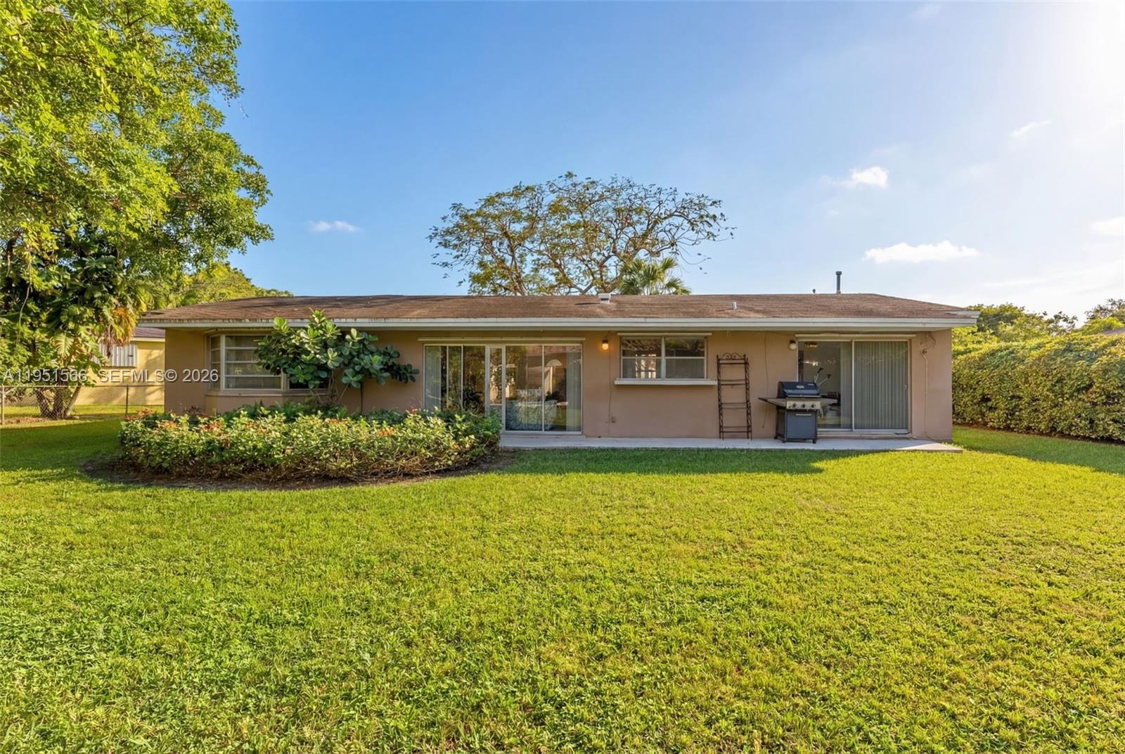 9925 Southwest 97th Place Miami, FL 33176 - Photo 7 of 15 a front view of a house with a garden and yard