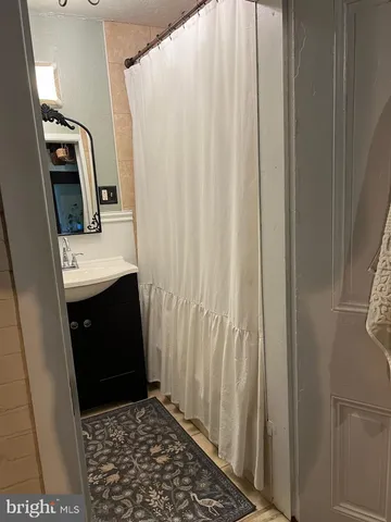 a bathroom with a sink a mirror and shower view