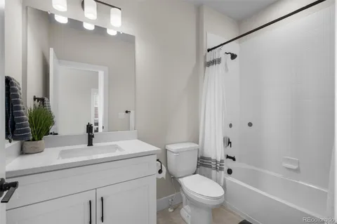 a bathroom with a sink a toilet a mirror a vanity and shower