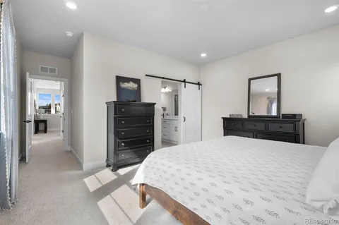 a large bedroom with a bed and a flat screen tv