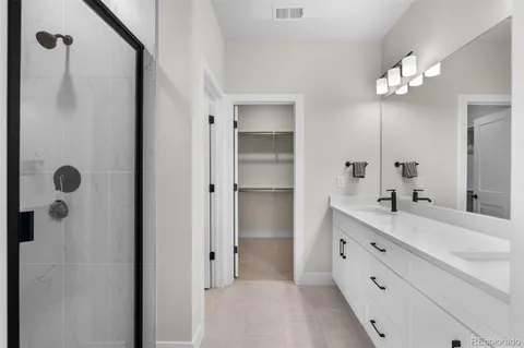 a bathroom with a double vanity sink mirror and shower
