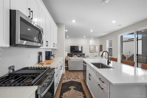 a kitchen with a sink stove top oven and refrigerator