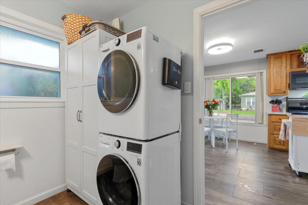 607 Short Street Smithville, TX 78957 - Photo 11 of 31 Dedicated laundry area featuring stacked appliances and built-in white cabinetry