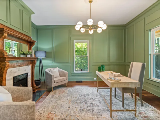 a living room with furniture a fireplace and a chandelier