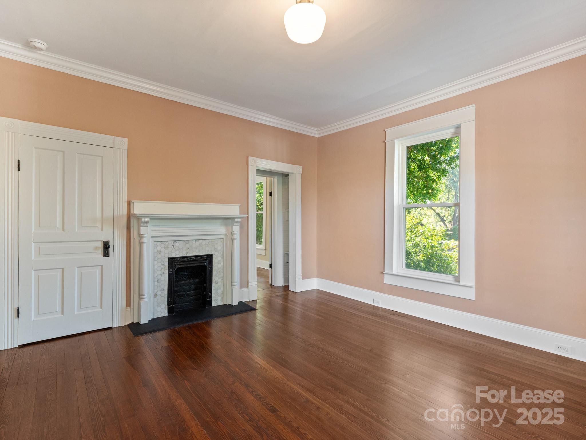 402 South Chester Street Gastonia, NC 28052 - Photo 29 of 48 an empty room with wooden floor fireplace and windows