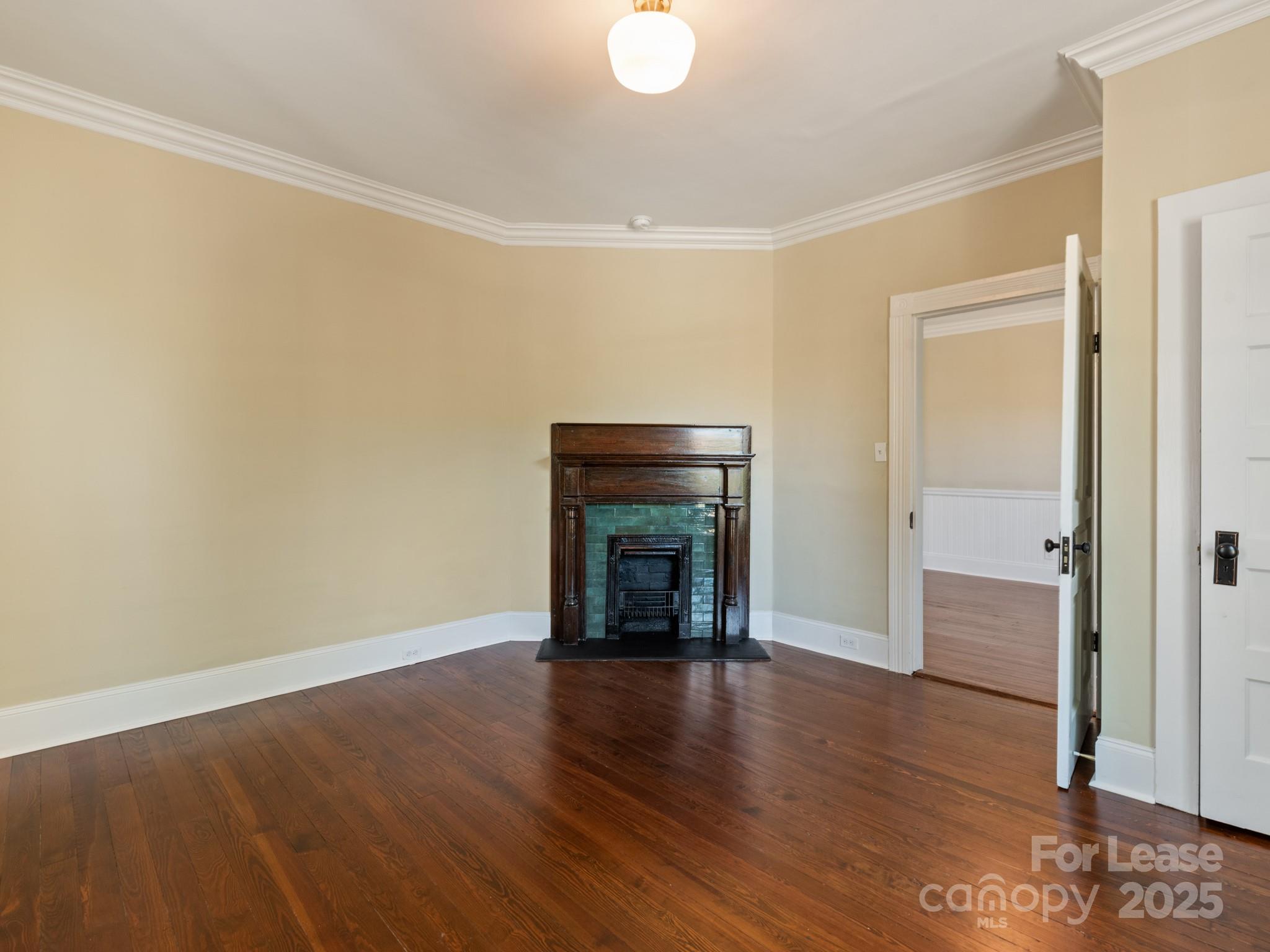 402 South Chester Street Gastonia, NC 28052 - Photo 31 of 48 an empty room with wooden floor and fireplace
