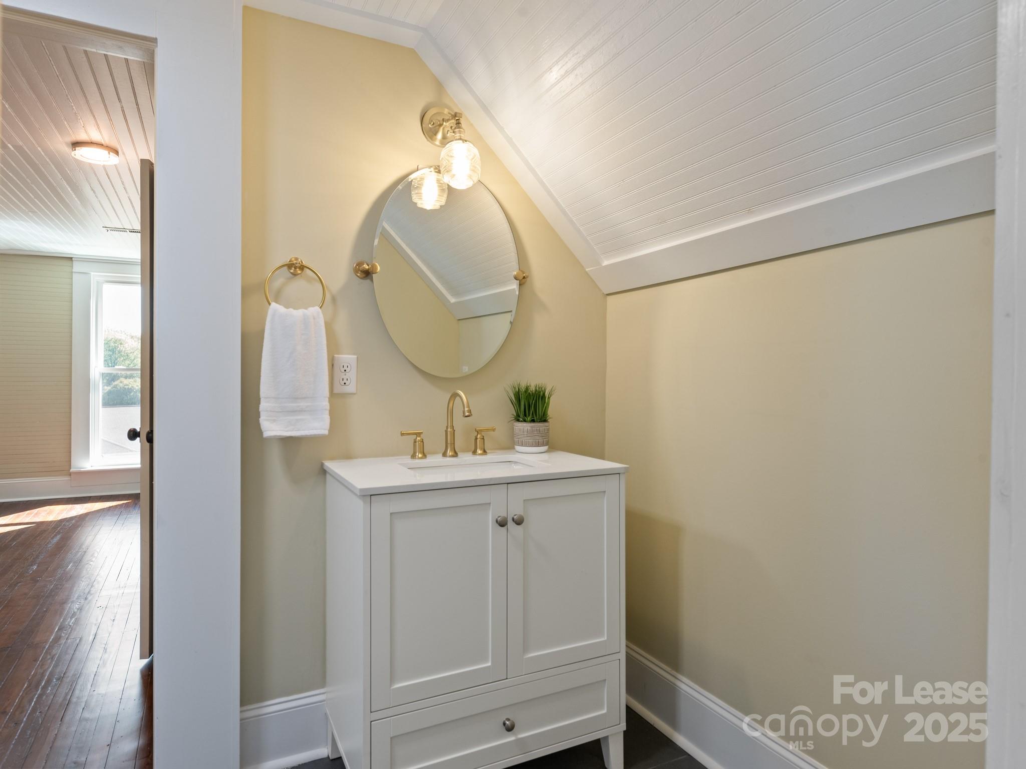 402 South Chester Street Gastonia, NC 28052 - Photo 37 of 48 a bathroom with a sink a mirror and a vanity