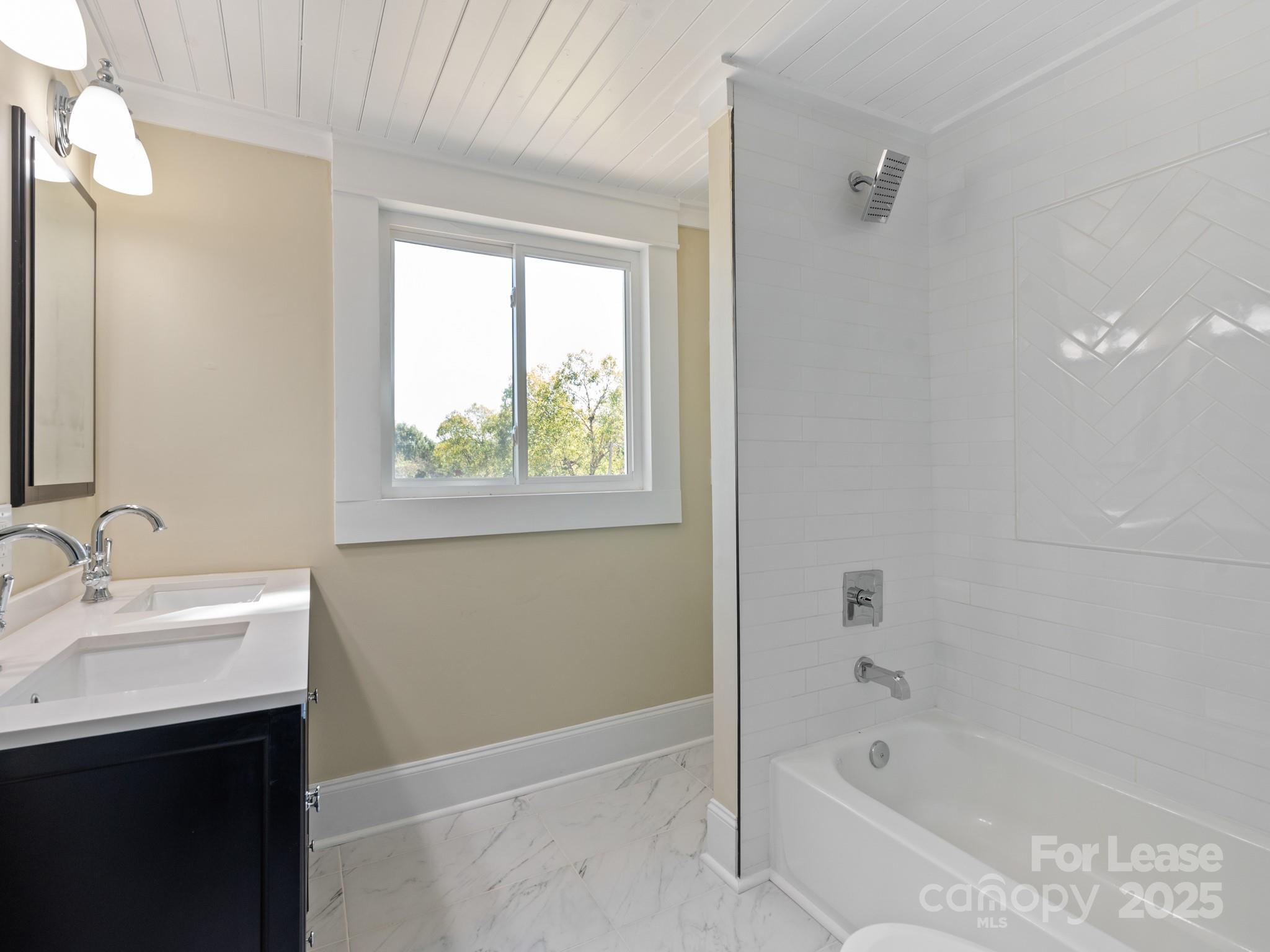 402 South Chester Street Gastonia, NC 28052 - Photo 40 of 48 a bathroom with a bathtub sink vanity and a mirror