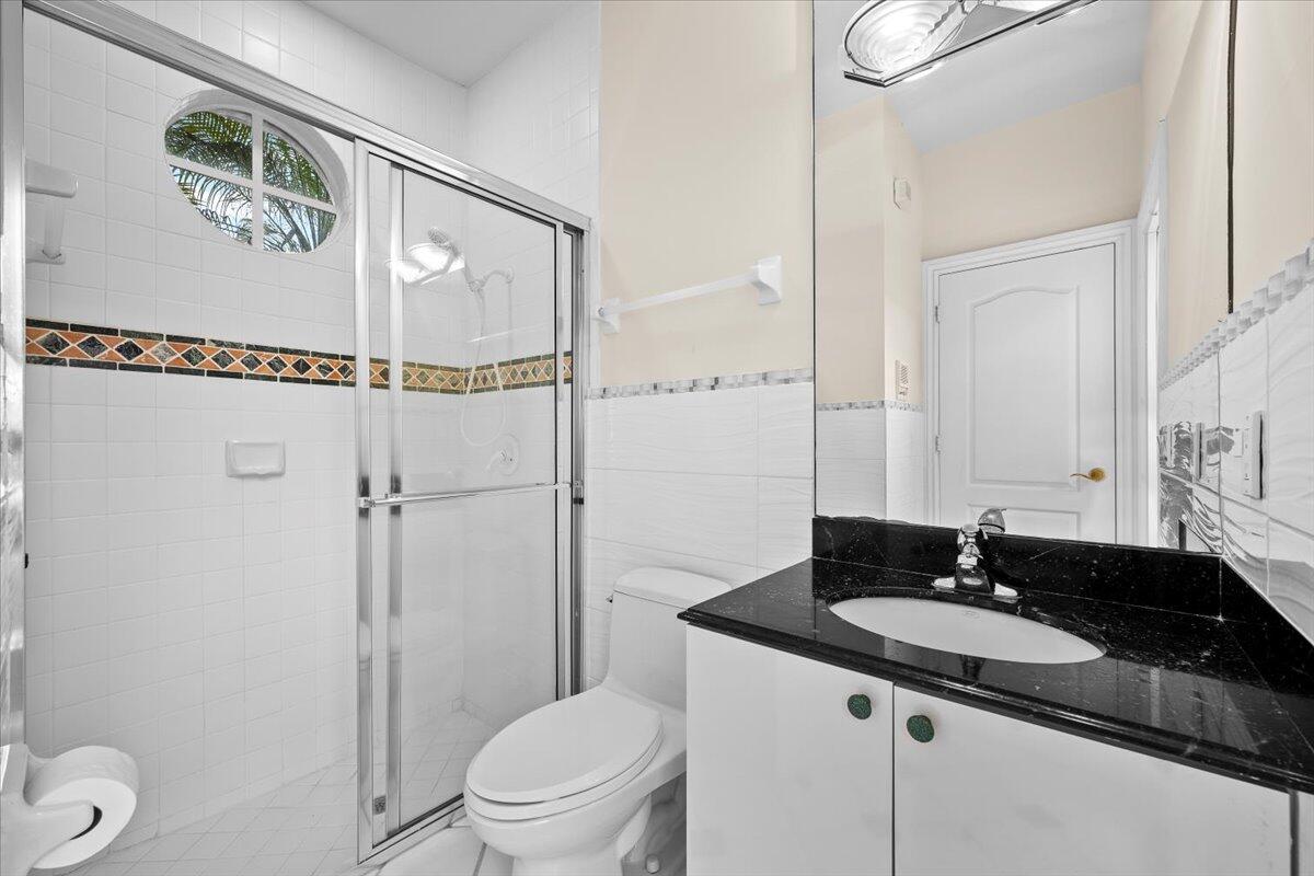 3241 Northwest 63rd Street Boca Raton, FL 33496 - Photo 13 of 75 a bathroom with a granite countertop sink a mirror and a toilet