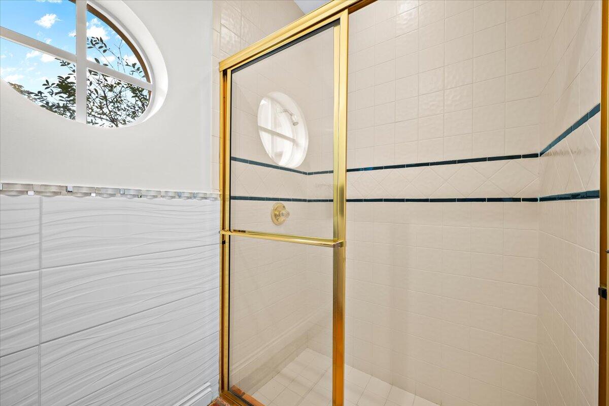 3241 Northwest 63rd Street Boca Raton, FL 33496 - Photo 42 of 75 a bathroom with a glass shower door and a window
