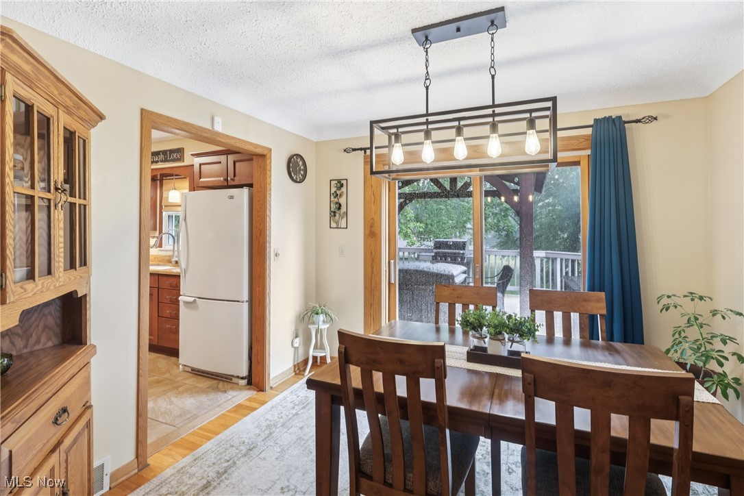 520 East Caston Road Uniontown, OH 44685 - Photo 11 of 47 Dining room featuring a chandelier, slider to back deck and wood flooring
