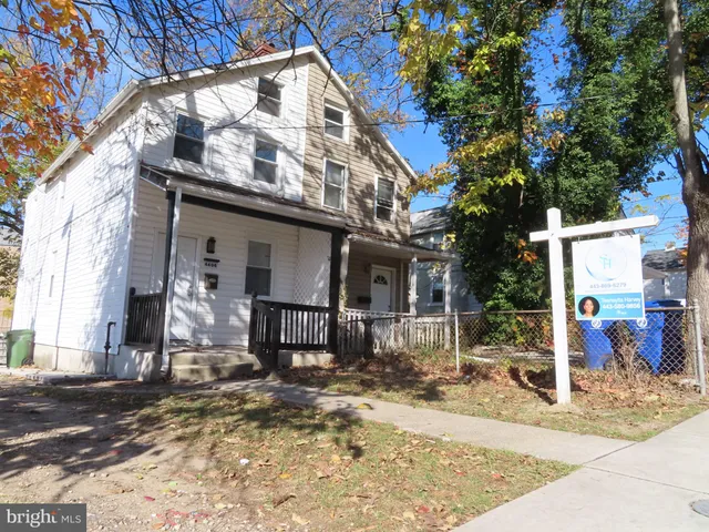 a view of a building with street sign and a tree