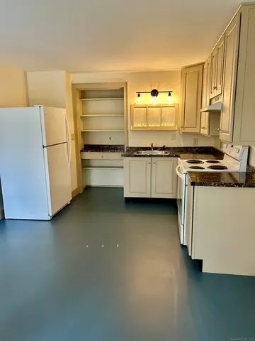 a kitchen with stainless steel appliances a stove and white cabinets