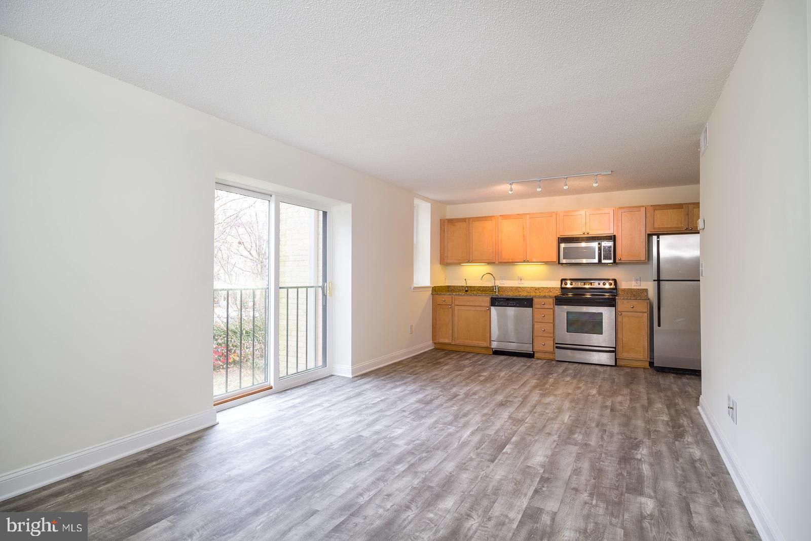 2630 Adams Mill Road Northwest, Unit 105 Washington, DC 20009 - Photo 5 of 13 a kitchen with stainless steel appliances a refrigerator sink and white cabinets