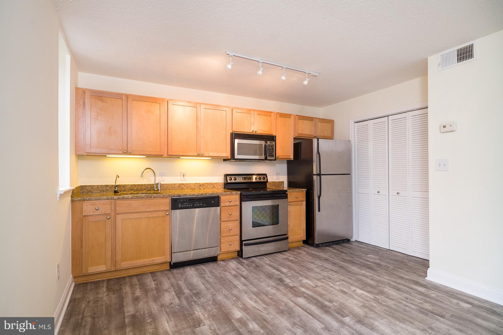 2630 Adams Mill Road Northwest, Unit 105 Washington, DC 20009 - Photo 7 of 13 a kitchen with stainless steel appliances granite countertop a refrigerator and a stove top oven