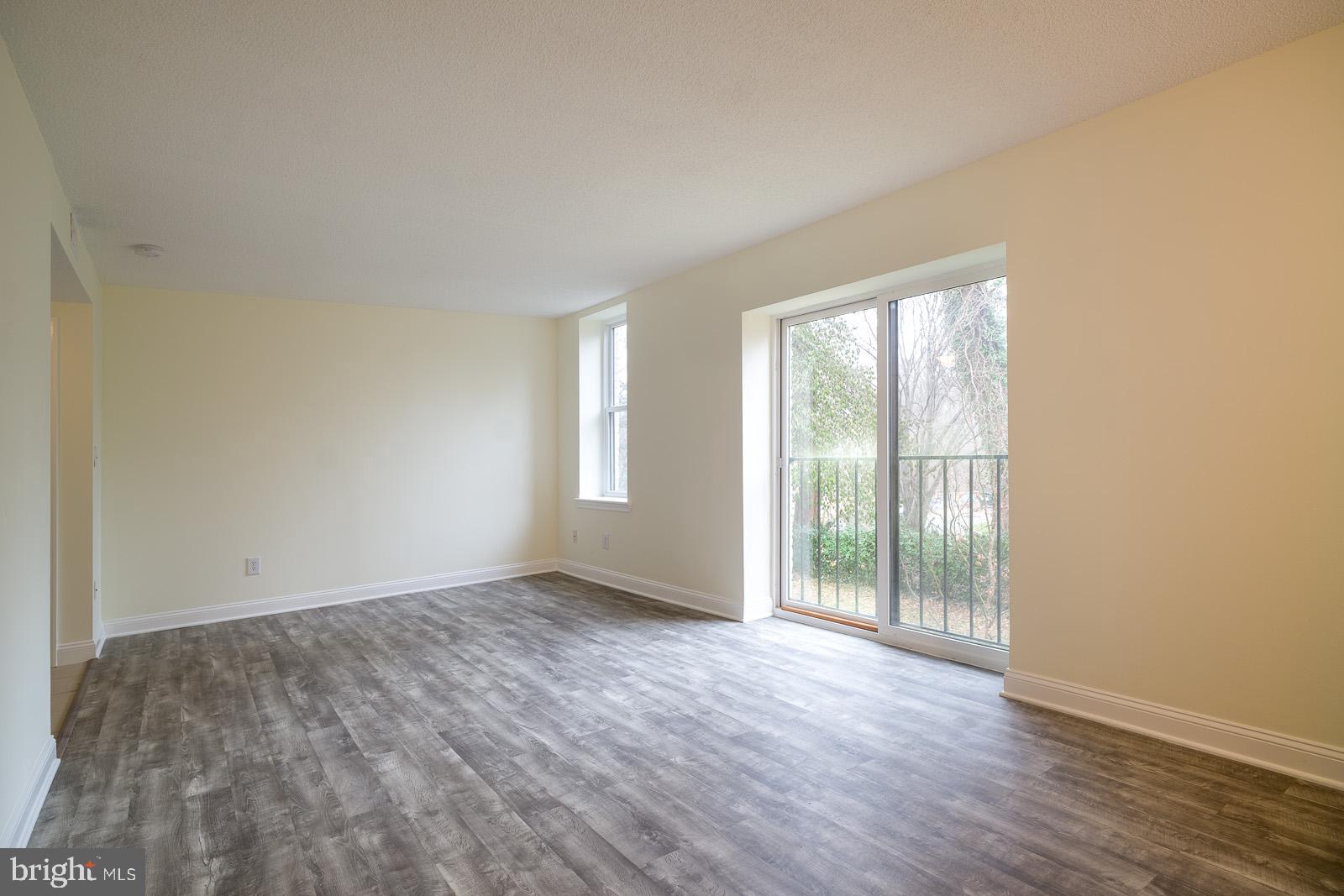 2630 Adams Mill Road Northwest, Unit 105 Washington, DC 20009 - Photo 10 of 13 an empty room with wooden floor and windows