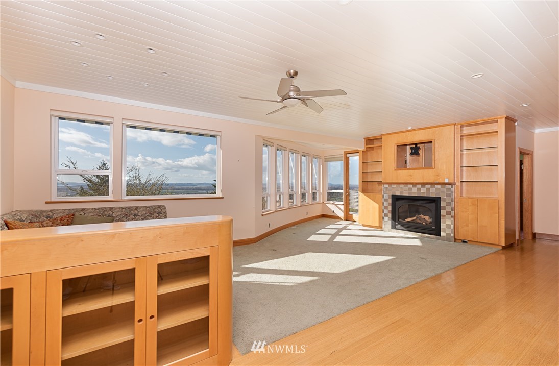 18564 Cascade View Drive Mount Vernon, WA 98274 - Photo 10 of 40 a view of a livingroom with a fireplace a ceiling fan and windows