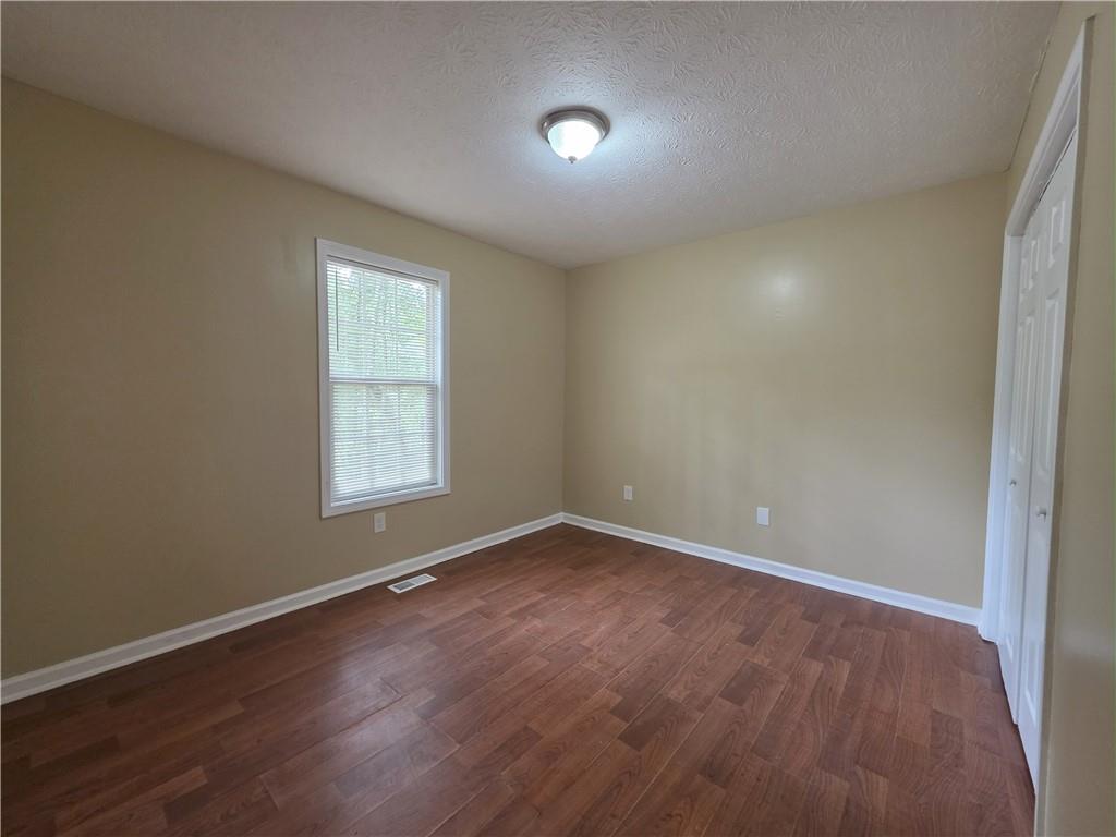 186 South Red Oak Way Temple, GA 30179 - Photo 11 of 19 an empty room with wooden floor and windows
