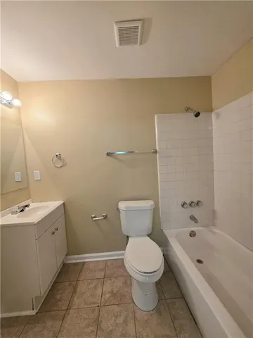 a bathroom with a toilet a sink a mirror a bathtub and shower
